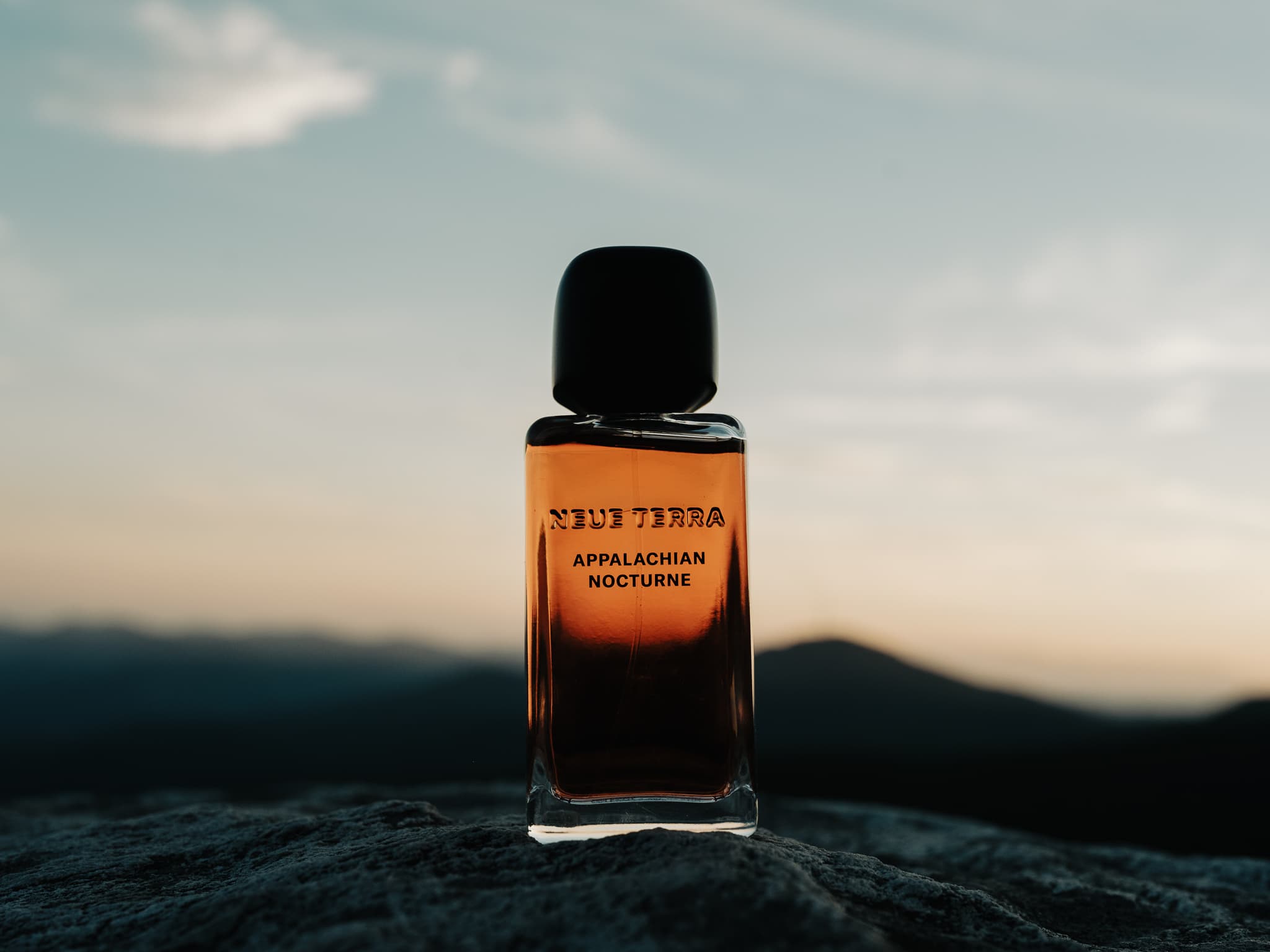 Appalachian Nocturne bottle against a mountain horizon